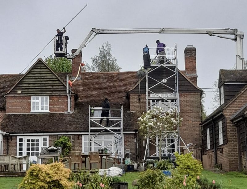 The Moss Cleaners using cherry picker and scaffolding to clean roof safely and professionally in Leatherhead, Surrey